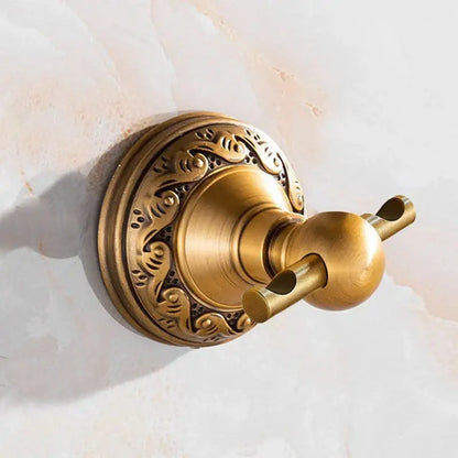 Antique brass double towel rack with ornate floral engraving and polished spherical hooks in brass bathroom accessories set