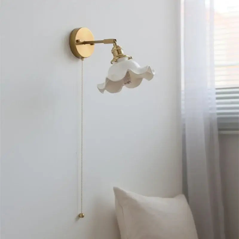 A delicate white ceramic led wall light with ruffled flower-like shade and vintage brass hardware for bedroom decorbites ceramic led wall