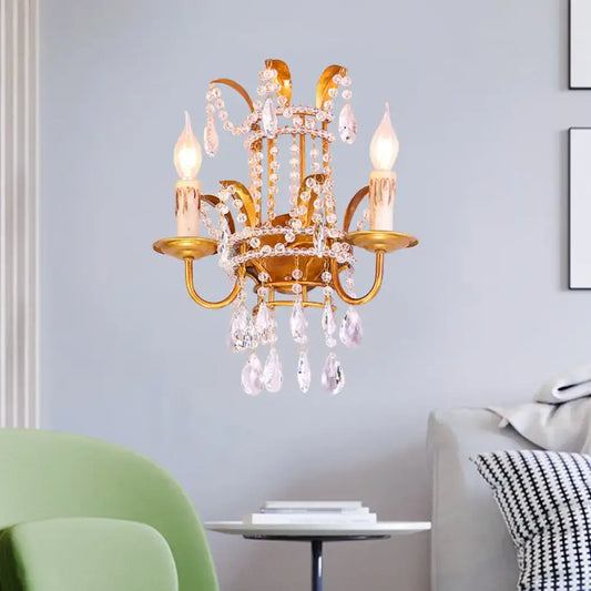 Gold-toned vintage brass chandelier with clear crystal droplets candle-style bulbs direct wired wall lamp for bedroom
