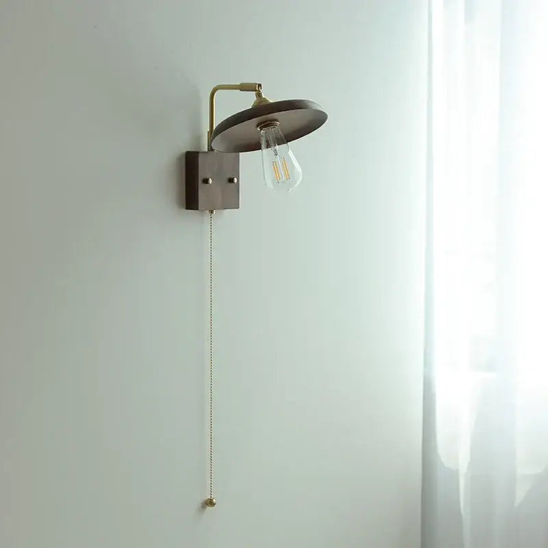 Vintage brass and dark wood wall light sconce with matte bronze circular shade and exposed Edison bulb decorbites copper