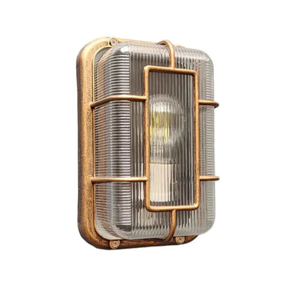 Vintage brass gas station canopy wall light with ribbed glass panel and protective metal cage for outdoor security