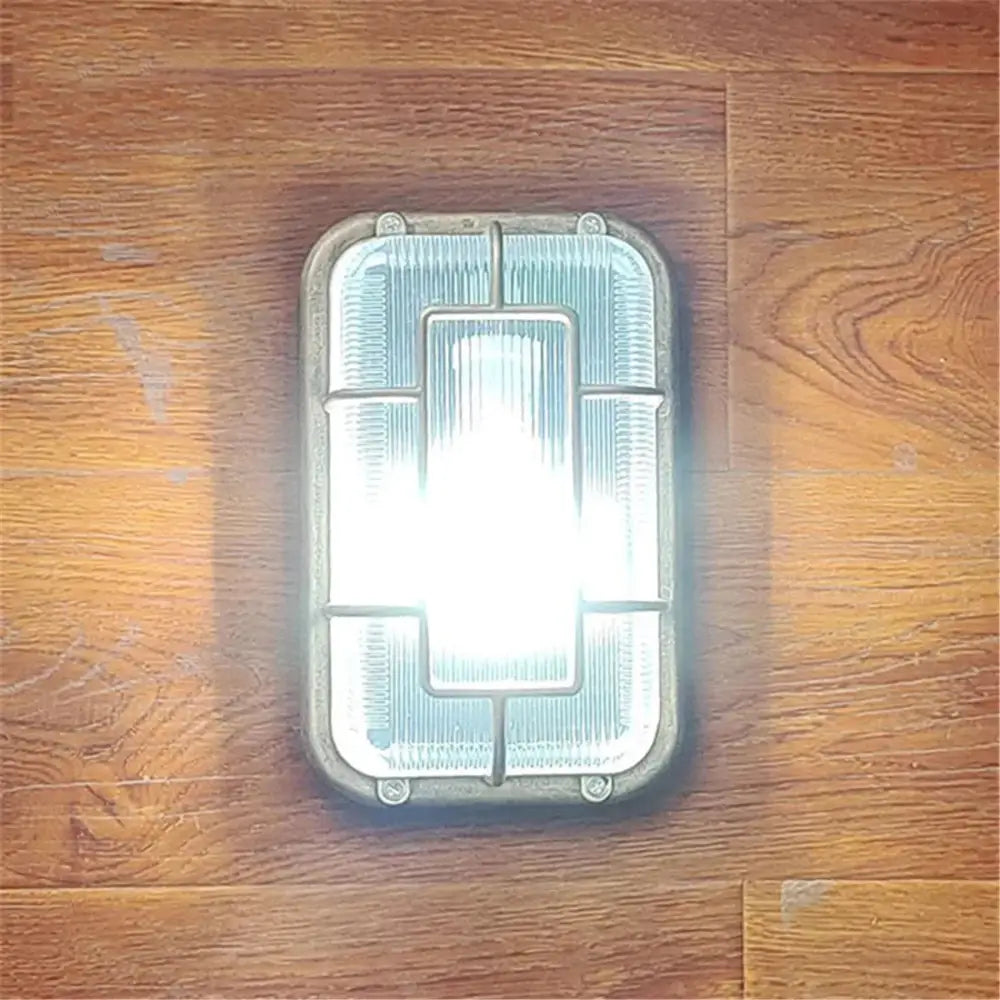Vintage brass gas station canopy wall light with frosted glass panel and metallic frame for outdoor security