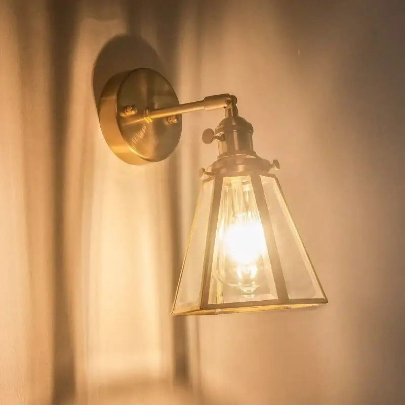 Vintage brass glass led wall light featuring a brass-finished sconce with a clear glass lantern shade and exposed bulb