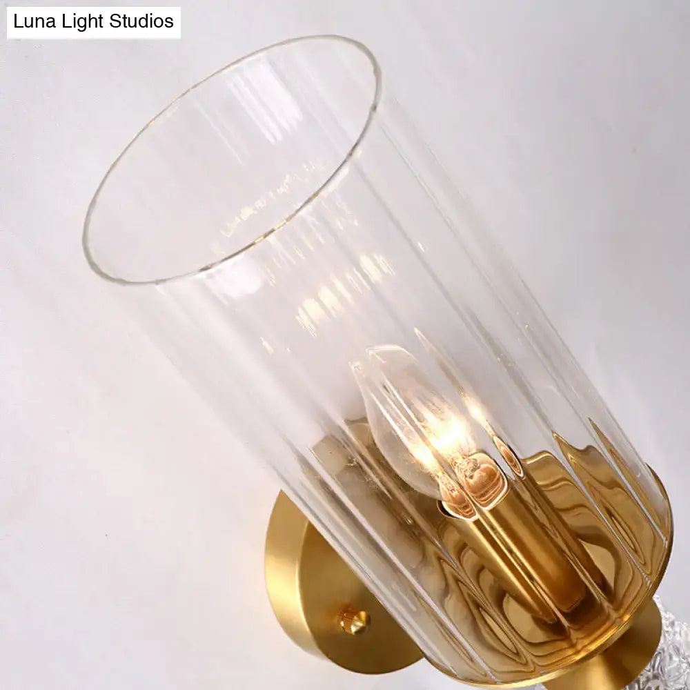 Vintage brass wall mounted lighting fixture with gold-toned glass shade and exposed filament bulb for bedroom use