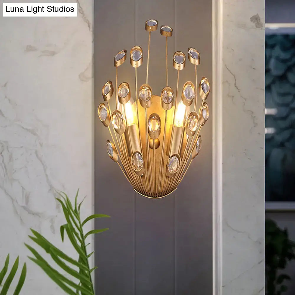 Gold-toned vintage brass wall sconce with peacock tail design featuring clear crystal accents and slender metallic rods