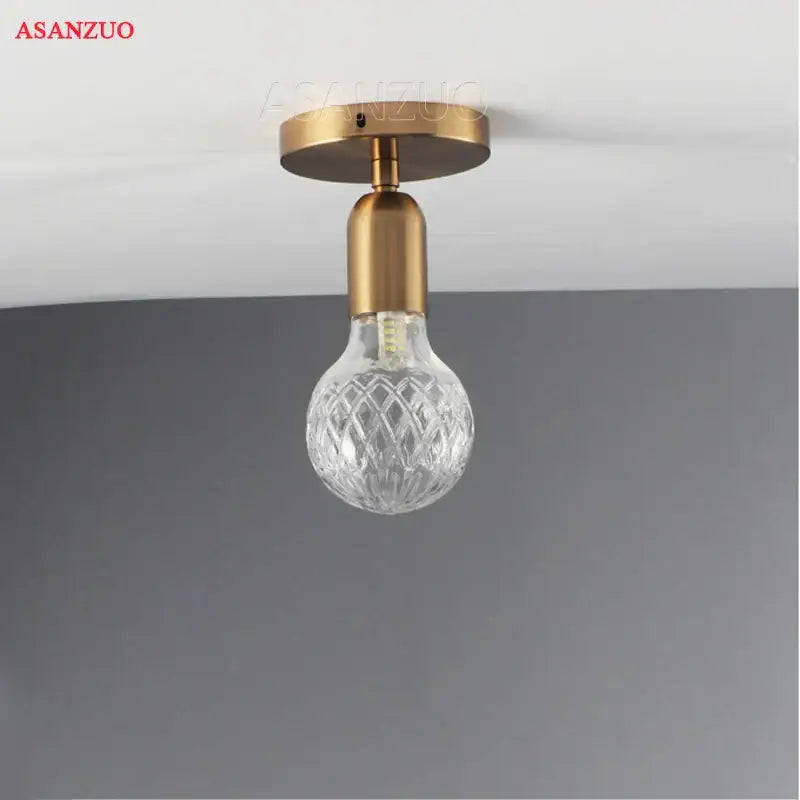 Vintage brass pendant lamp with faceted clear glass bulb and brass finish ceiling-mounted for dining room use