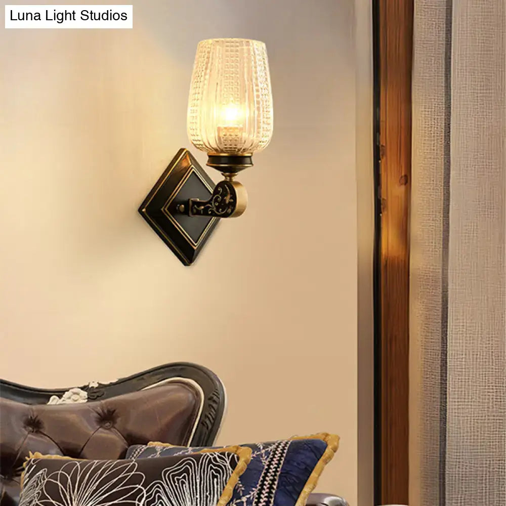 Vintage brass sconce with clear textured glass shade featuring antique brass finish for living room light