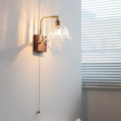 Vintage brass wall light with clear glass flower-shaped lampshade and dangling crystal droplets for bedroom decorbites clear glass