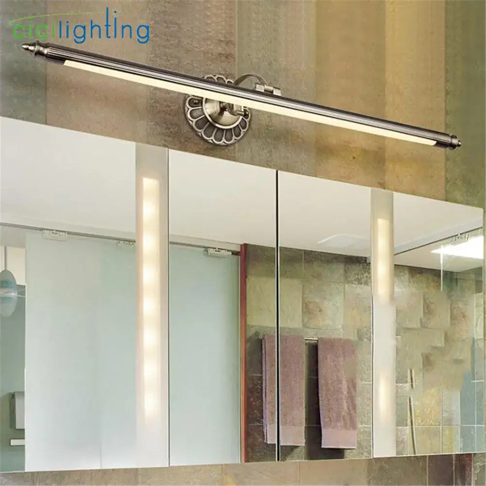Silver-toned ornate wall lamp with bronze led bathroom light featuring a decorative fluted mounting plate by decorbites