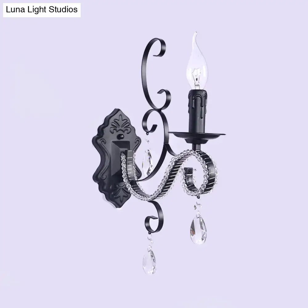 Black wrought iron wall mounted lamp with crystal droplets and candle style bulb for vintage living room decor