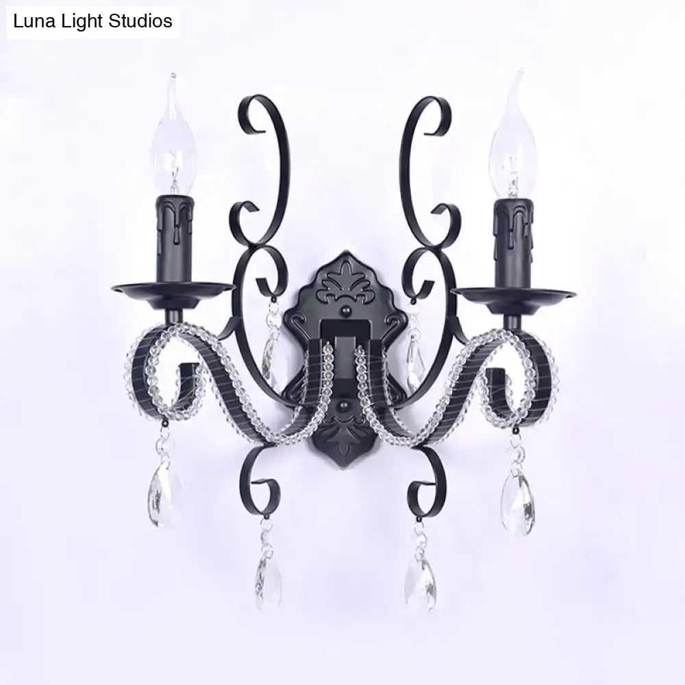 Black wrought iron wall mounted lamp with crystal accents and two candle-style bulbs for vintage living room decor
