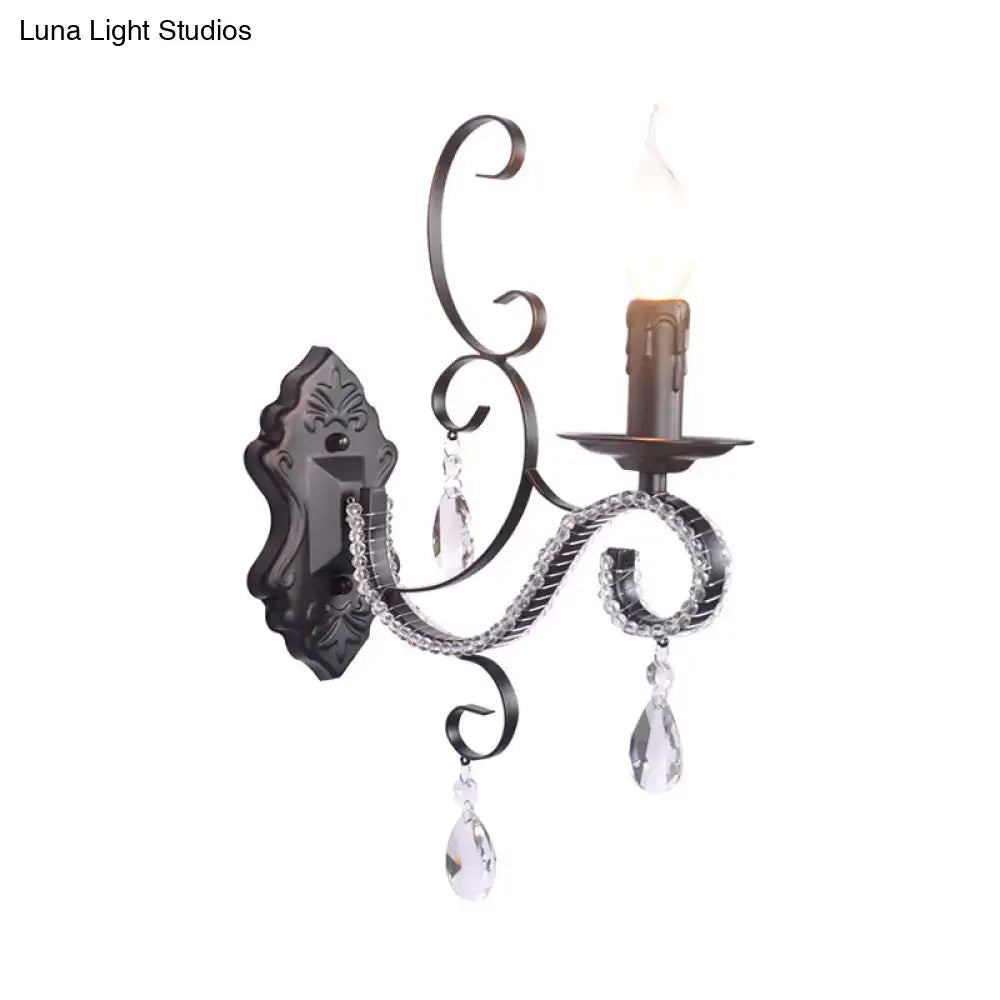 Elegant black wrought iron wall mounted lamp with crystal teardrop pendants and candle-style bulb for living room use