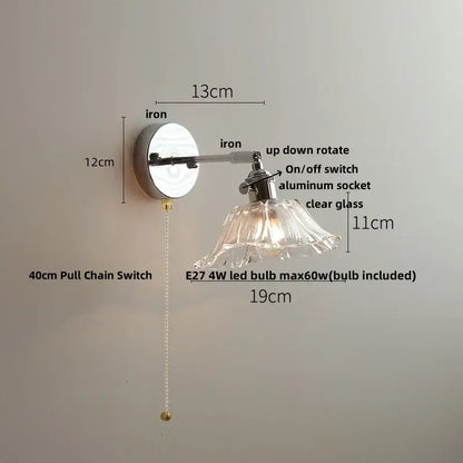 Vintage brushed nickel led wall light with polished iron arm and clear glass petal-shaped shade for bedroom use
