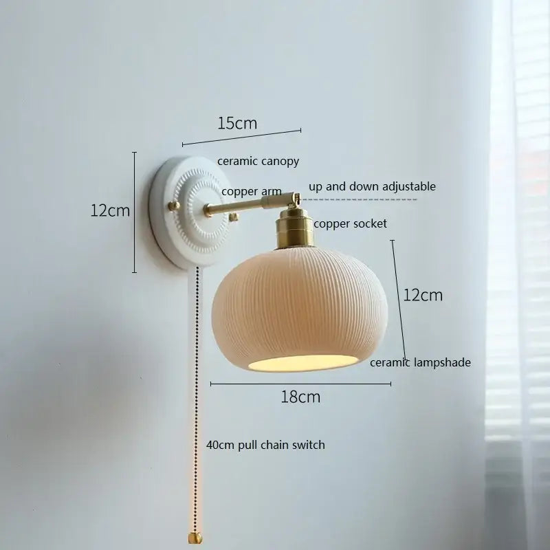 Cream-colored decorbites ceramic wall lamp with ribbed fluted glass shade and brass accents for bedroom decor