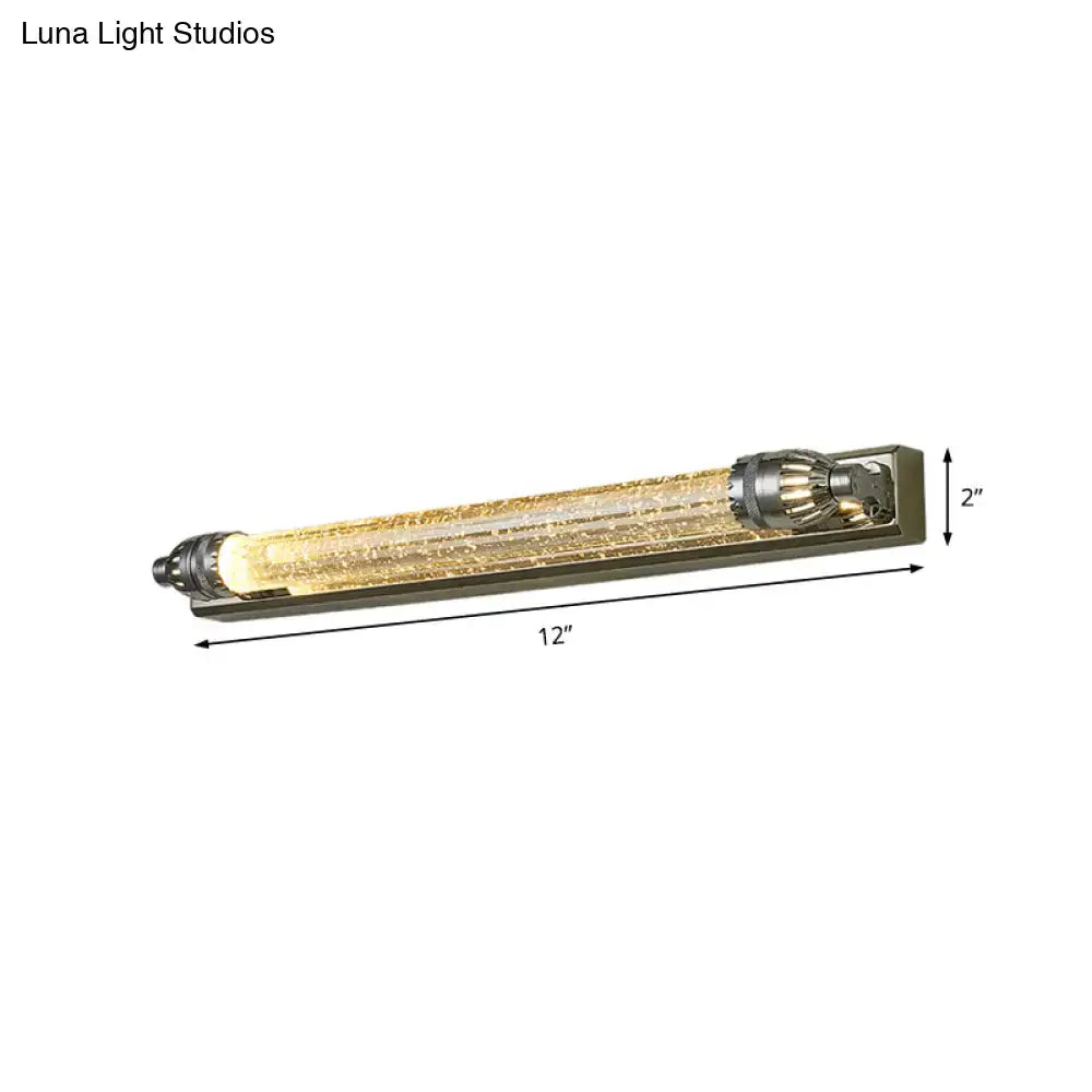 Vintage chrome and crystal led vanity light with textured glass tube and metallic end caps emitting warm glow