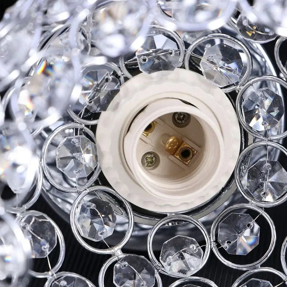 Clear crystal beads encircle a white ceramic light socket with gold contacts in a vintage chrome crystal ball ceiling light