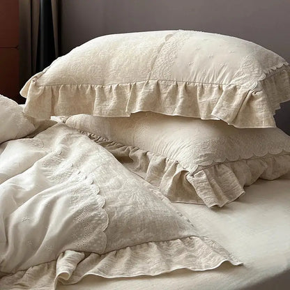 Cream-colored linen pillowcases with soft textured fabric and jacquard lace ruffles in a vintage bedding set