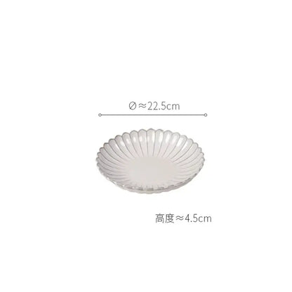 A white ceramic dish with fluted petal rim and glossy finish from vintage cream scalloped dining table set