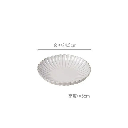 A white ceramic dish with a scalloped rim and ridges from a vintage cream scalloped dining table set