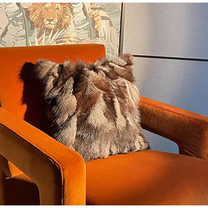 A vintage dark brown and black fox fur cushion cover with plush texture on an orange velvet armchair decorbites fox fur