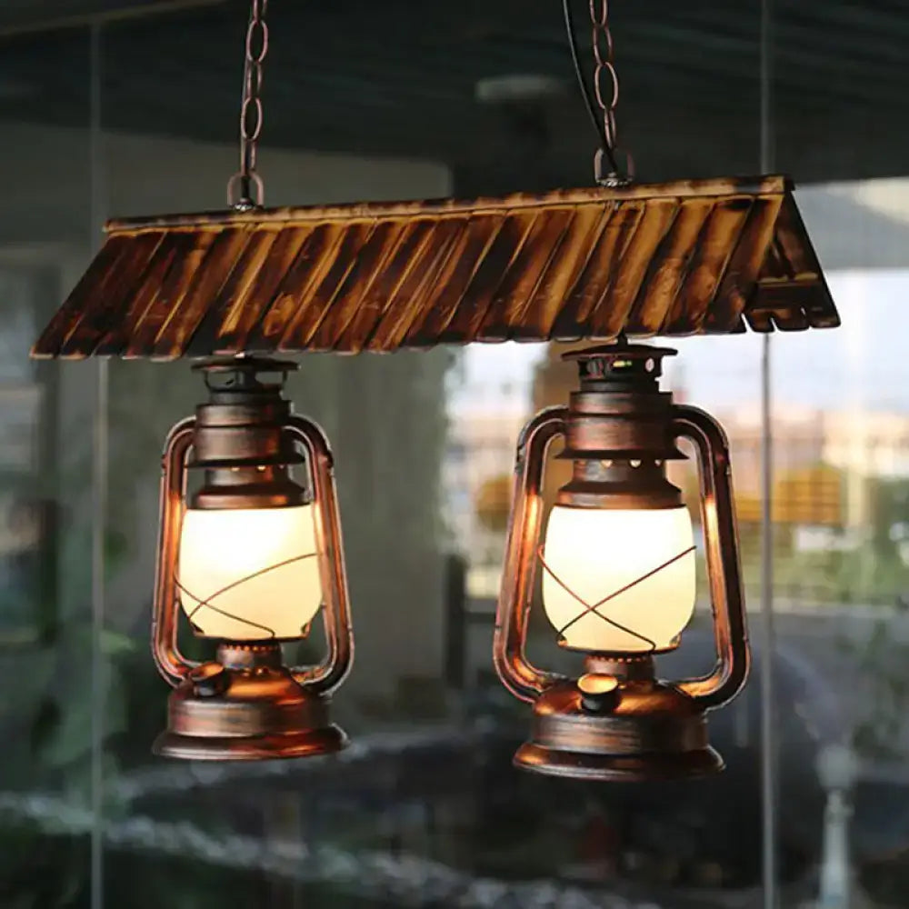 Vintage dark brown metal island light kitchen pendant light with copper lanterns and warm glowing bulbs under wooden canopy