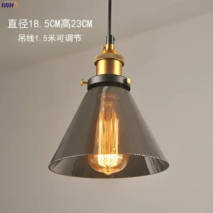 Industrial-style glass pendant light with dark gray shade and brass-finished hardware for dining room lighting