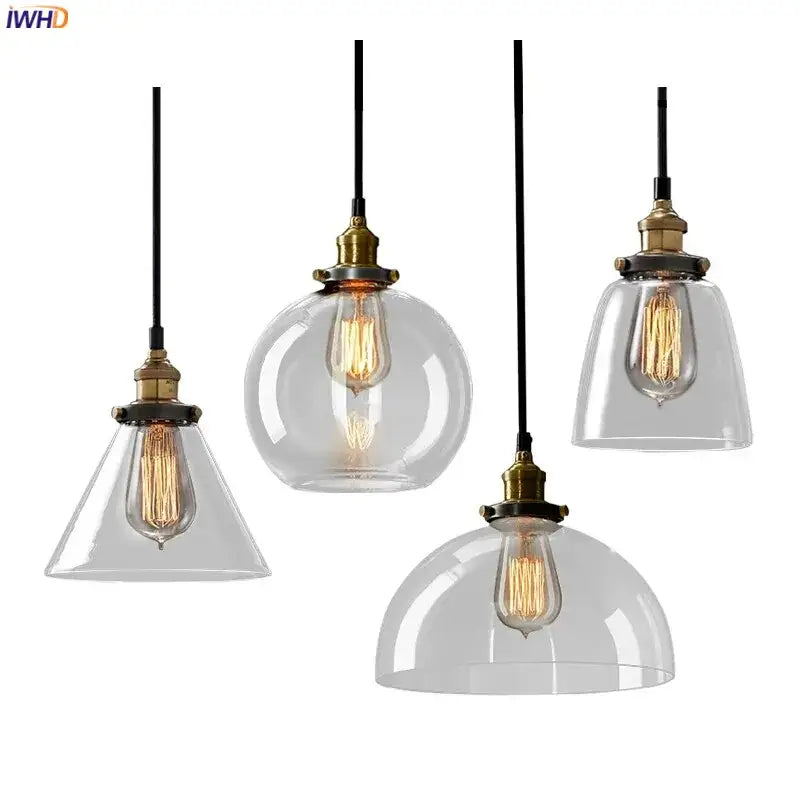Set of four clear glass pendant lights with brass fixtures and exposed filament bulbs for dining room accents