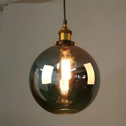Warm-toned vintage glass pendant lights set of 4 with brass accents and exposed filament bulbs for dining room use