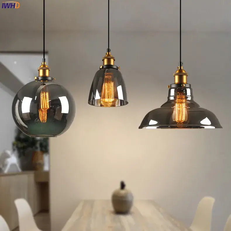 Three vintage glass pendant lights with smoked glass shades and brass fixtures for dining room accents