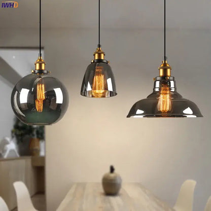 Three vintage glass pendant lights with smoked glass shades and brass fixtures for dining room accents