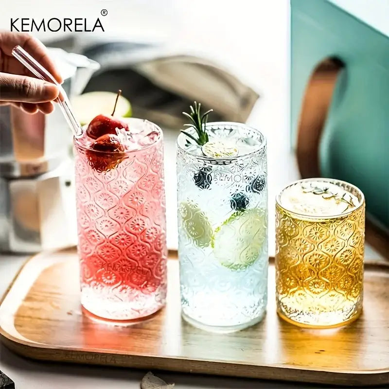 Three kemorela vintage glassware set tall tumblers with embossed floral patterns filled with colorful garnished drinks