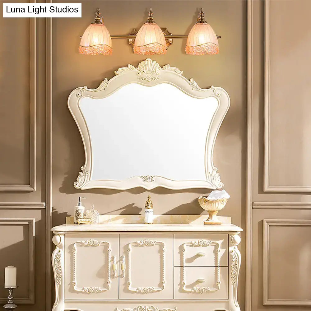 Antique white ornate bathroom vanity with carved details and matching mirror complementing vintage amber glass sconces