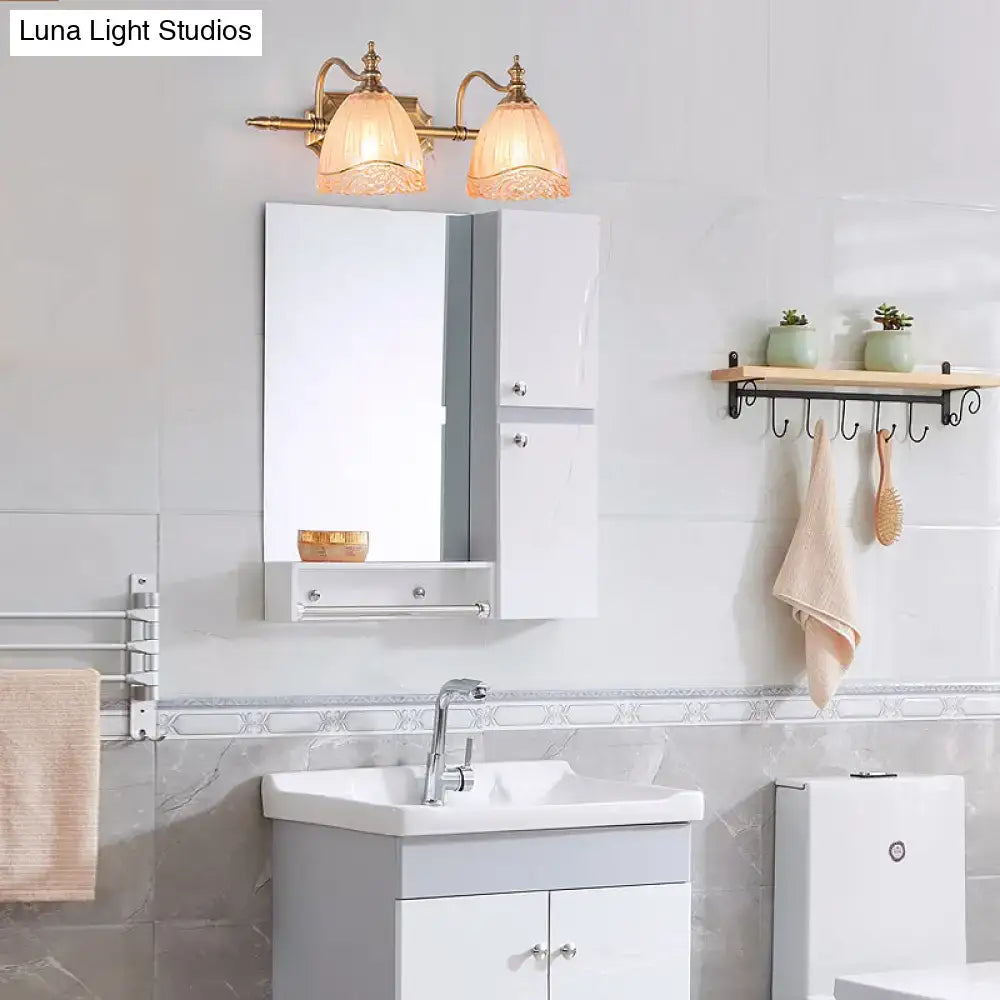 Brass-finished wall-mounted vanity light with two warm amber glass shades ideal for bedroom lighting