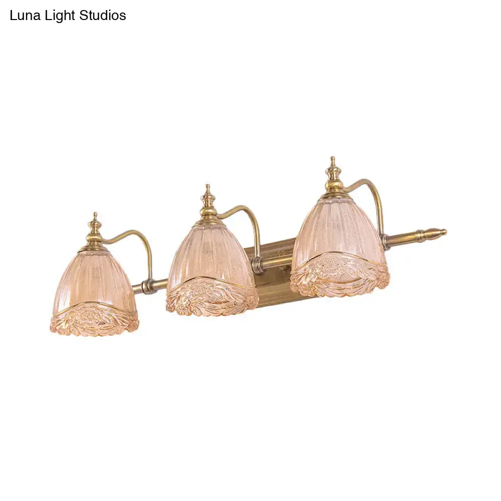 A three-light vintage floral amber glass wall sconce with brass arms and pink-tinted etched glass shades for bedroom use