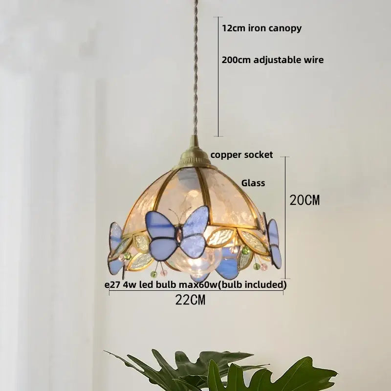 Delicate tiffany-style pendant lamp with stained glass butterflies in blue gold framed by a decorbites copper wire glass socket