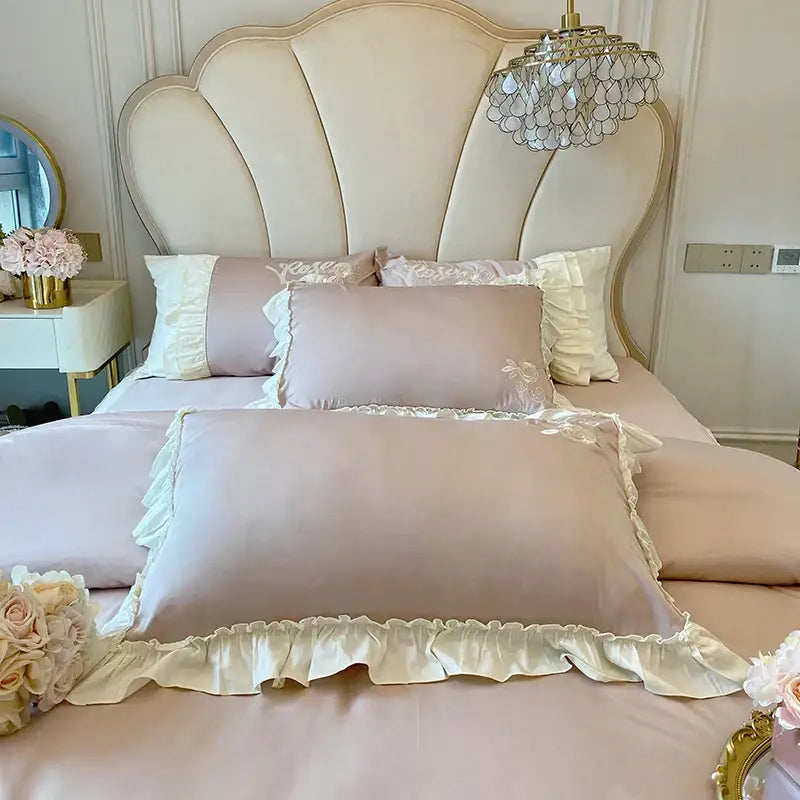 A soft blush pink satin pillowcase with cream vintage french ruffles and floral embroidery from bedding set