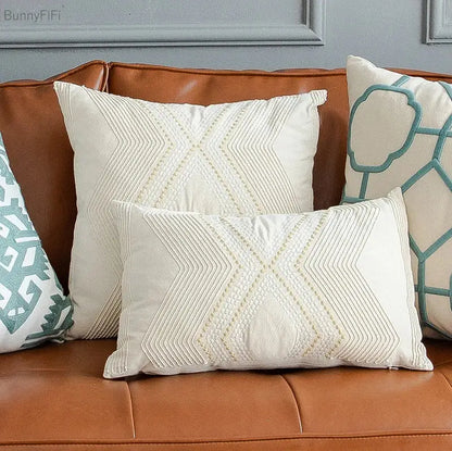 Cream-colored cushion cover with stitched x-shape pattern featuring decorbites geometric ivory vintage gold embroidery
