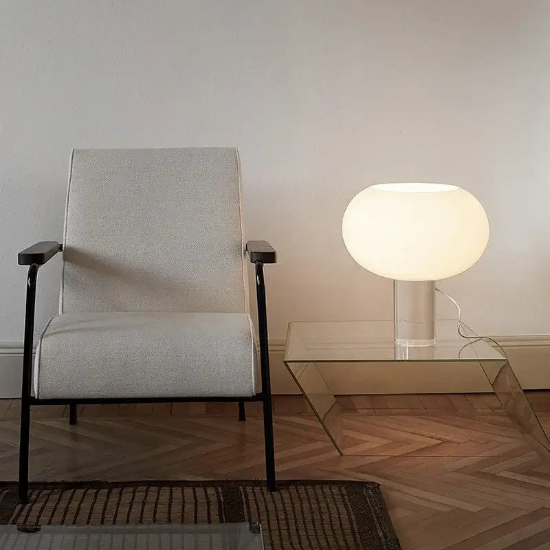 A sleek glowing white spherical vintage glass buds table lamp on a glass side table for warm bedroom decorbites buds table