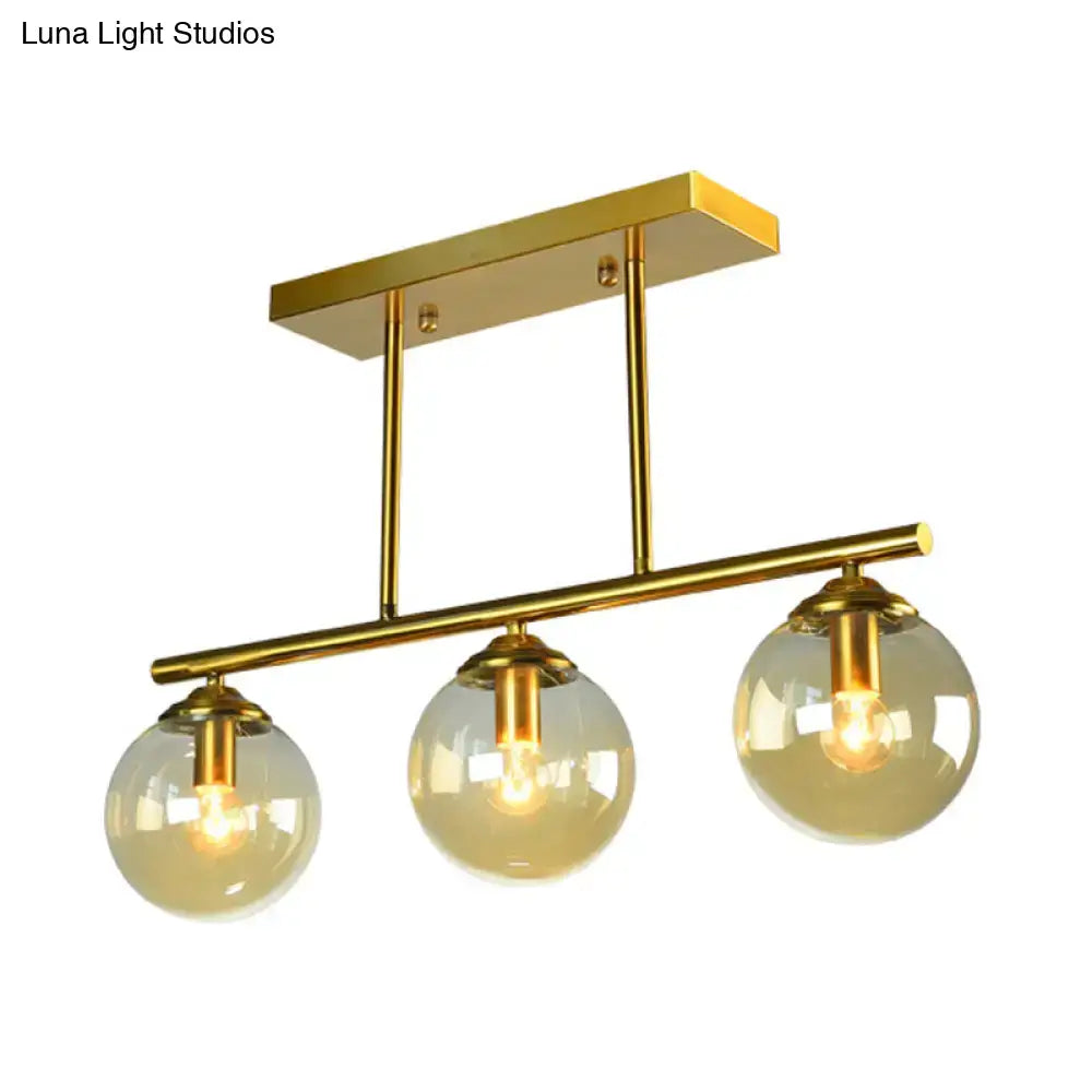 Gold-finished DecorBites vintage 3-bulb pendant lamp with three clear amber glass sphere globes for island lighting