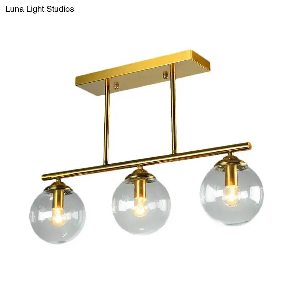 Gold-toned DecorBites vintage 3-bulb pendant lamp with clear amber glass sphere shades and brass metal arms for island lighting