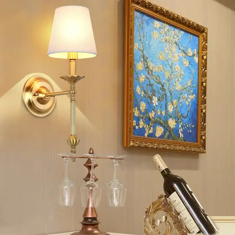 Vintage gold and cream led wall sconce with brass adjustable arm and white lampshade holding three hanging wine glasses decorbites copper vintage