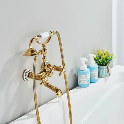 Vintage gold and black bathtub faucet with ornate gold finish and white ceramic handles featuring blue floral patterns