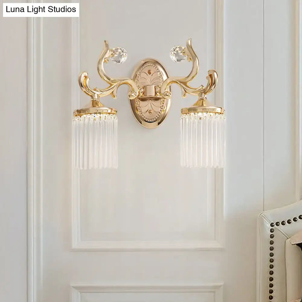 Vintage gold wall mounted light with ornate crystal accents and cascading clear pipe prisms for elegant bedroom decor