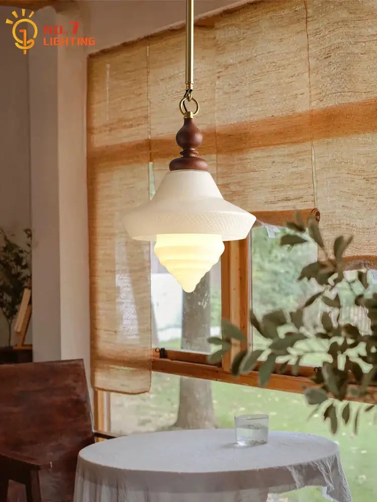 A vintage cream glass pendant light with dark wood top featuring decorbites gold lustre for kitchen island decor