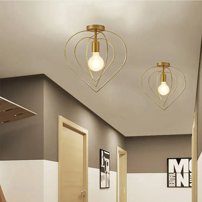 Gold heart-shaped pendant light featuring a visible bulb inside decorbites gold metal cage for restaurant and bar decor