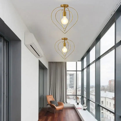 Two gold-toned heart-shaped pendant lights with exposed bulbs featuring decorbites gold metal cage design for restaurants and bars