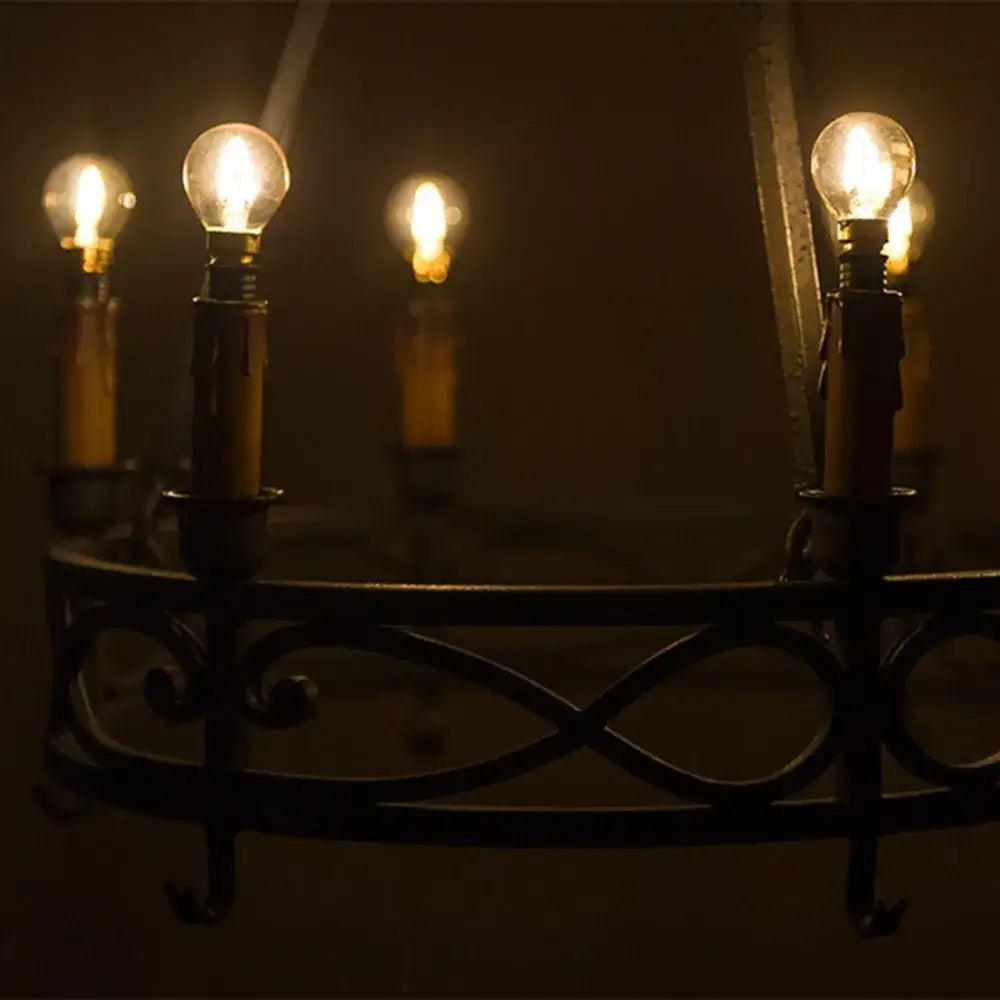 Dark wrought iron chandelier with multiple glowing decorbites gold tint g40 led bulbs for warm bedroom lighting