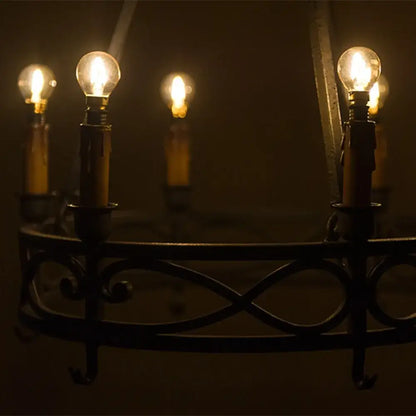 Dark wrought iron chandelier with multiple glowing decorbites gold tint g40 led bulbs for warm bedroom lighting