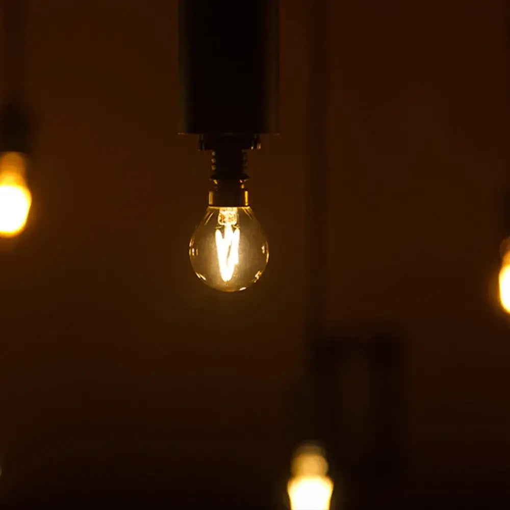 Warmly glowing vintage gold tint g40 led bulb with clear glass and visible filament for bedroom decorbites lighting