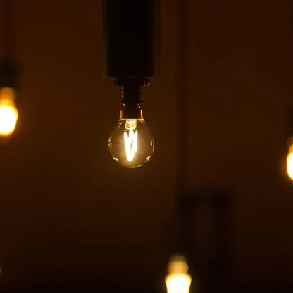 Warmly glowing vintage gold tint g40 led bulb with clear glass and visible filament for bedroom decorbites lighting